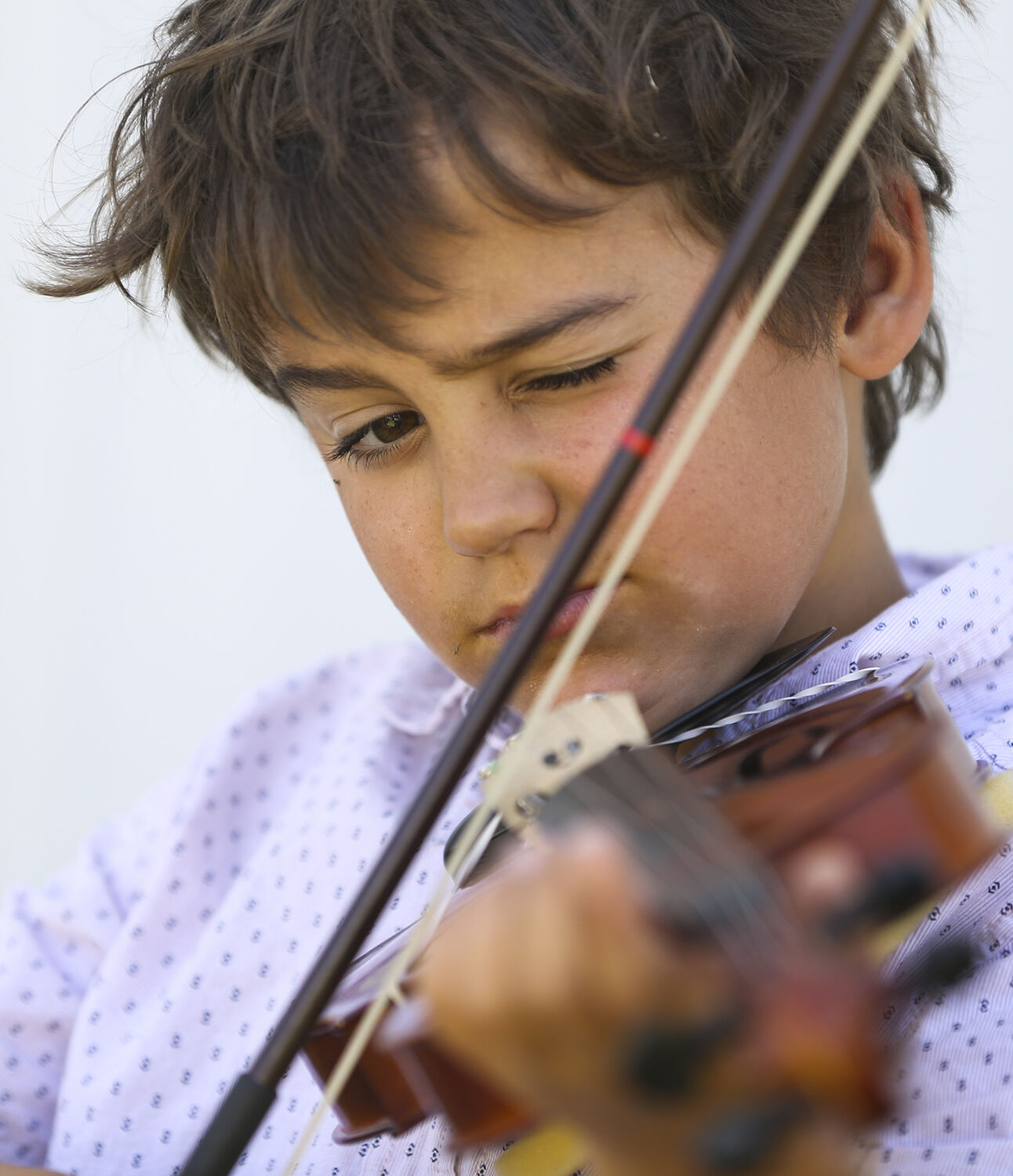 Trell Schiffer focuses on his fingers and bow while practicing with the session